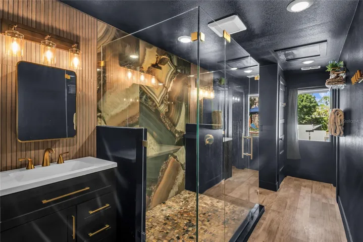 Oversized spa inspired bathroom features with dual vanities, two private water closets, a large glass-enclosed shower and elevated finishes throughout