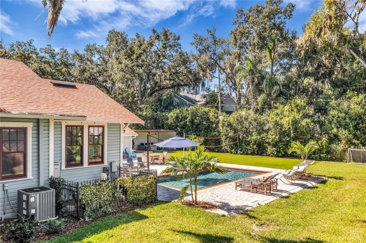 The enormous fully fenced backyard is designed for year-round enjoyment with a gas-heated saltwater sport pool, outdoor kitchen, expansive brick paved deck, detached covered lanai, and low-maintenance turf.