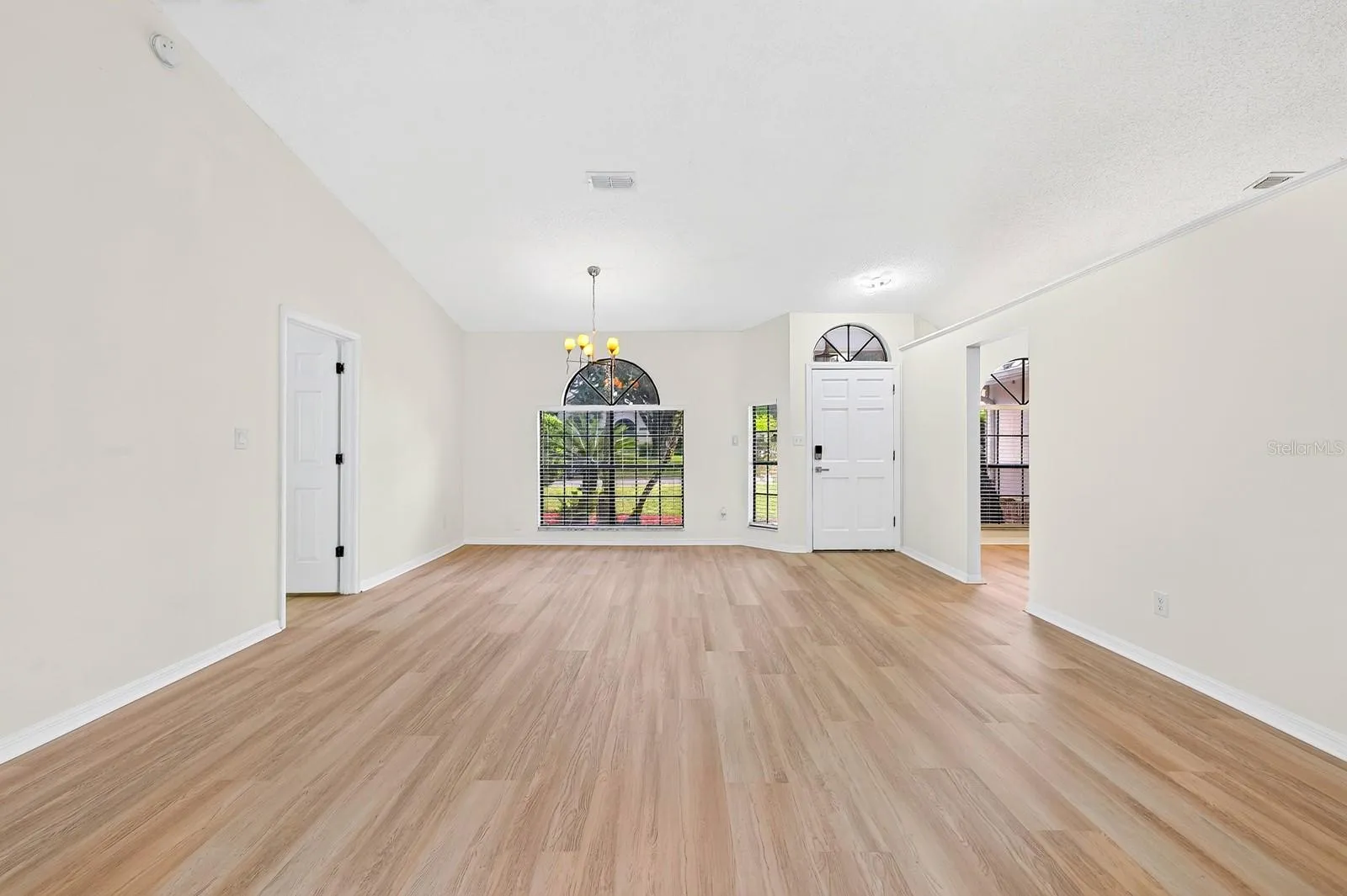 The formal Dining Room features an ELEGANT ARCHED LUNETTE WINDOW and flows into the Living Room.