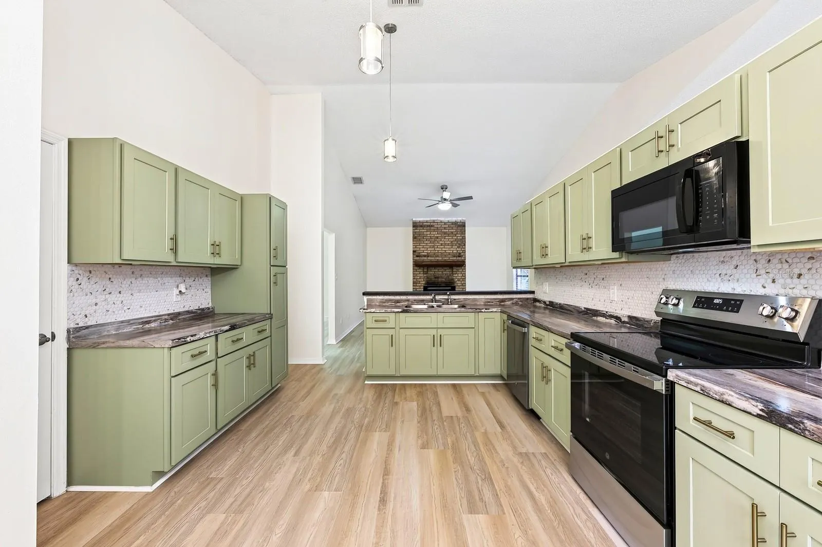 The beautifully REFRESHED KITCHEN offers an abundance of NEW CABINETRY and counter space, a convenient breakfast bar and NEW STAINLESS STEEL APPLIANCES.