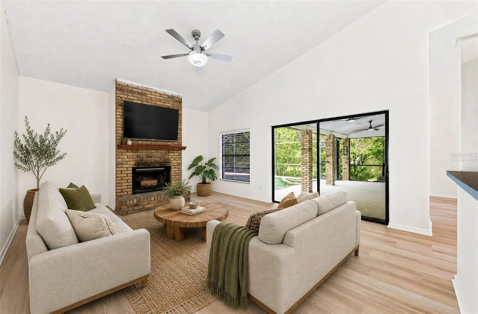 In the Family Room, a WOOD-BURNING FIREPLACE creates a cozy focal point, and sliding glass doors provide another EASY CONNECTION to the outdoor living space. Virtually Staged