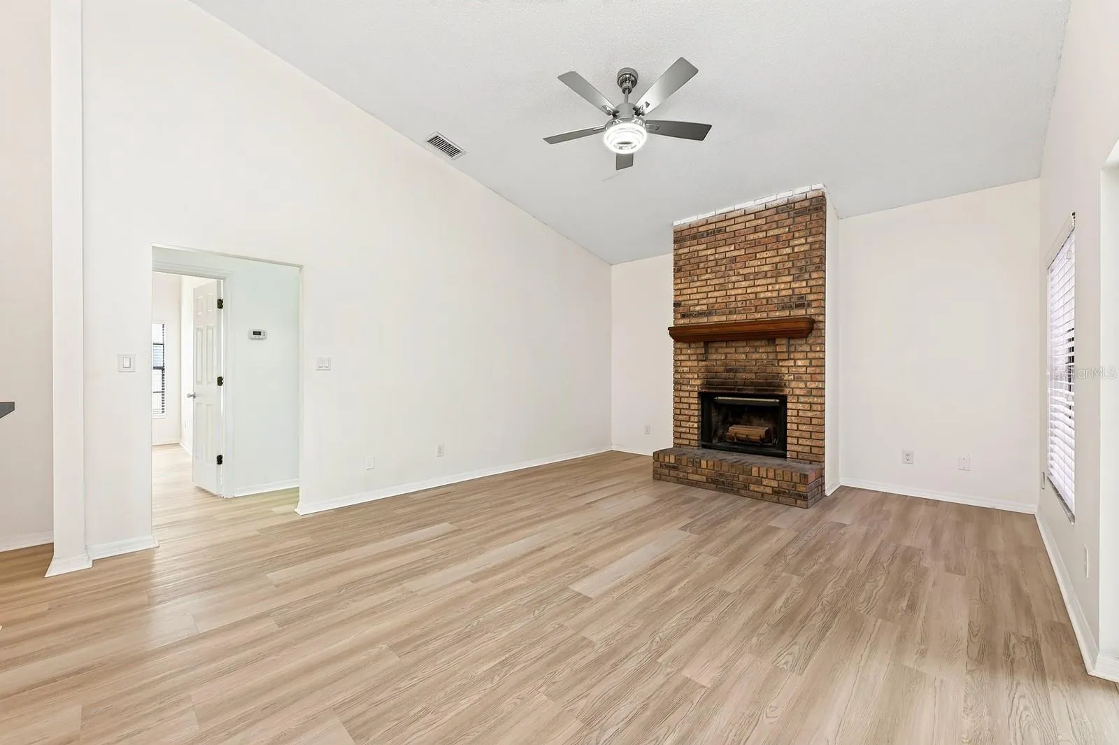 In the Family Room, a WOOD-BURNING FIREPLACE creates a cozy focal point, and sliding glass doors provide another EASY CONNECTION to the outdoor living space.
