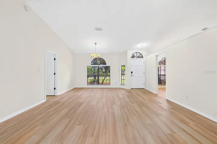 The formal Dining Room features an ELEGANT ARCHED LUNETTE WINDOW and flows into the Living Room.