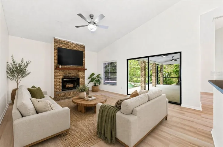 In the Family Room, a WOOD-BURNING FIREPLACE creates a cozy focal point, and sliding glass doors provide another EASY CONNECTION to the outdoor living space. Virtually Staged