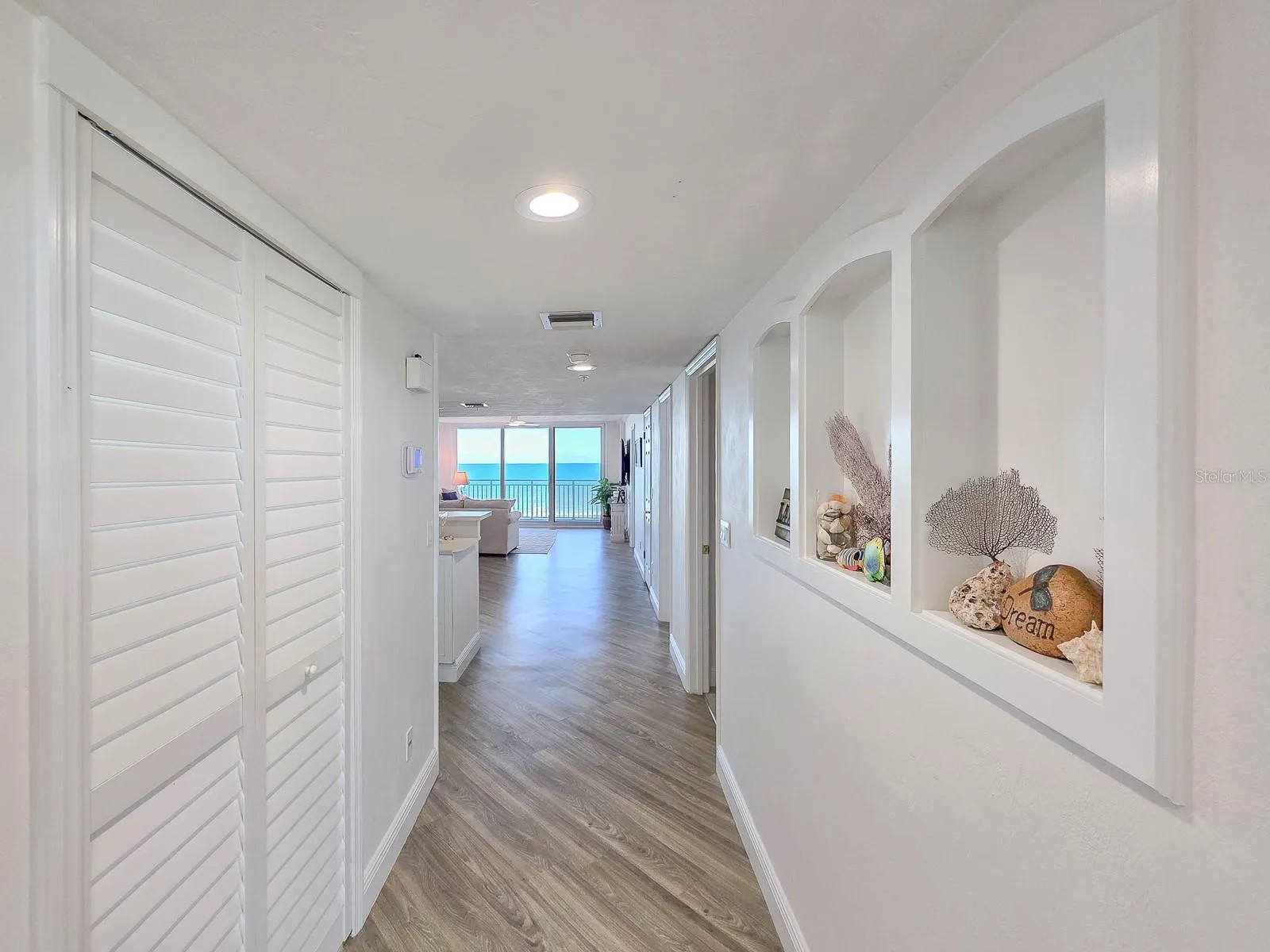 Hallway with laundry on left and built-ins on left.