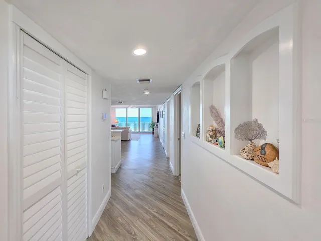 Hallway with laundry on left and built-ins on left.