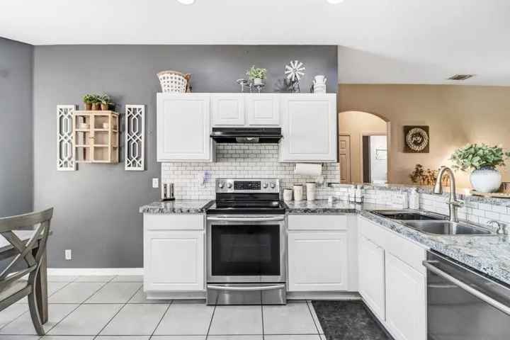Kitchen with stainless appliances, granite and beautiful backsplash