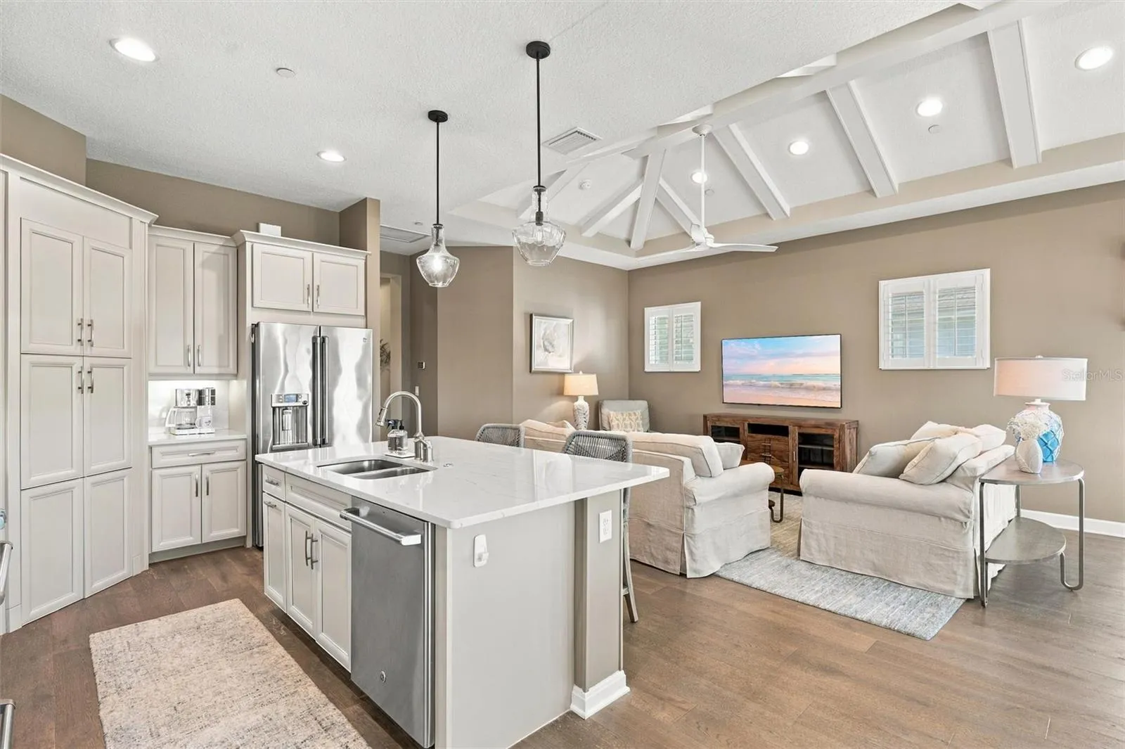 The well-designed kitchen shines with GE Café stainless steel appliances, elegant quartz countertops, and a spacious walk-in pantry.