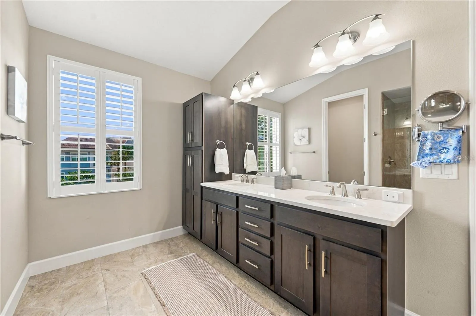 The spacious primary ensuite features dual vanities, a large walk-in shower, a private water closet, and convenient access to one of the suite’s two walk-in closets.
