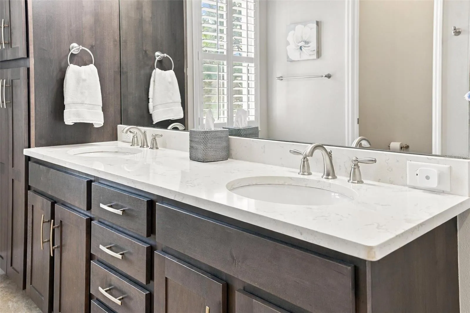 The spacious primary ensuite features dual vanities, a large walk-in shower, a private water closet, and convenient access to one of the suite’s two walk-in closets.