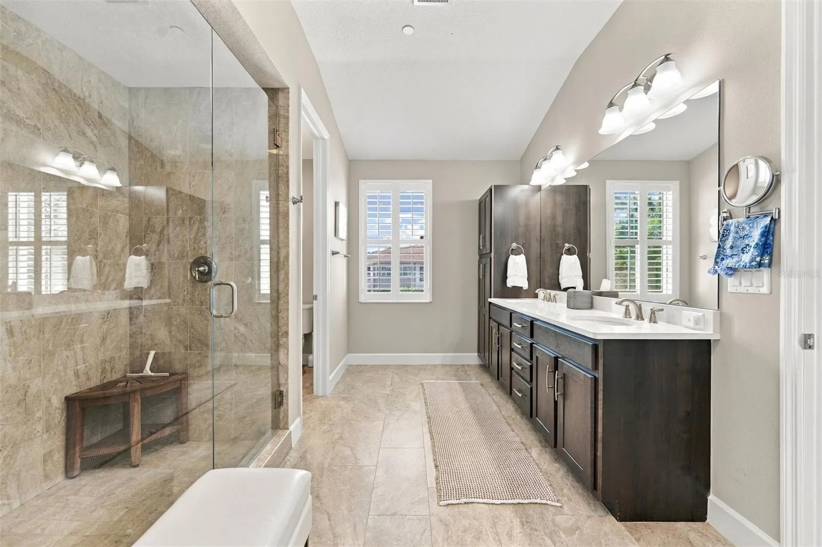 The spacious primary ensuite features dual vanities, a large walk-in shower, a private water closet, and convenient access to one of the suite’s two walk-in closets.