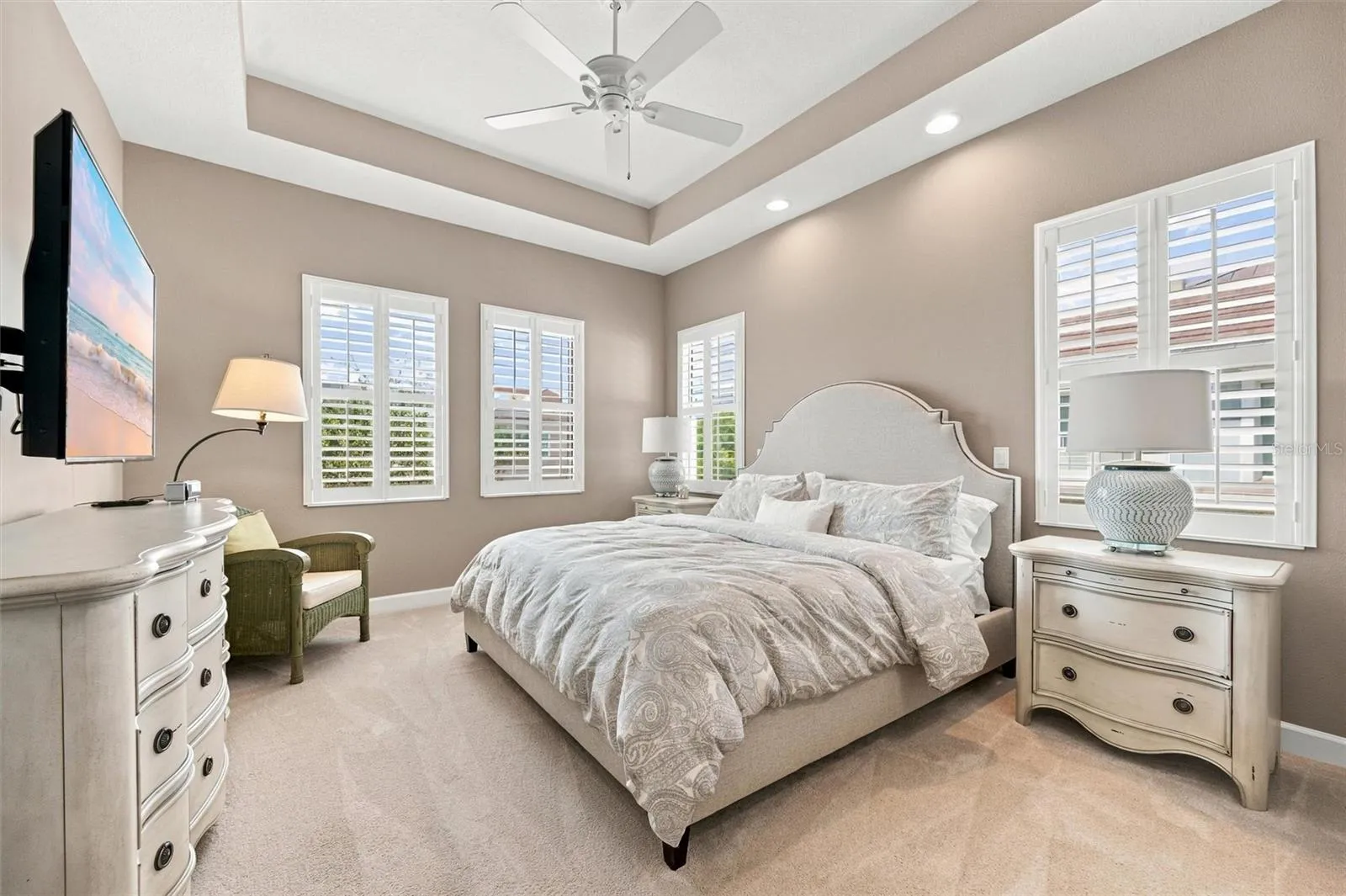 Spacious primary suite, featuring an elegant tray ceiling and two walk-in closets for ample storage.