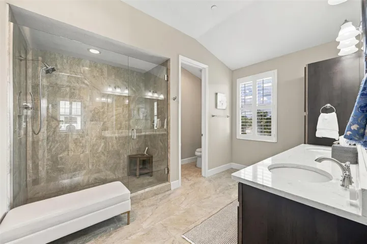 The spacious primary ensuite features dual vanities, a large walk-in shower, a private water closet, and convenient access to one of the suite’s two walk-in closets.