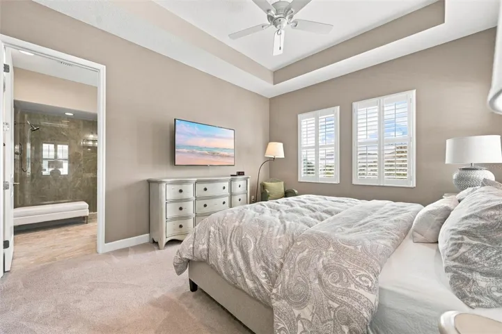 spacious primary suite, featuring an elegant tray ceiling and two walk-in closets for ample storage.