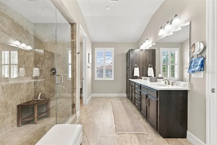 The spacious primary ensuite features dual vanities, a large walk-in shower, a private water closet, and convenient access to one of the suite’s two walk-in closets.
