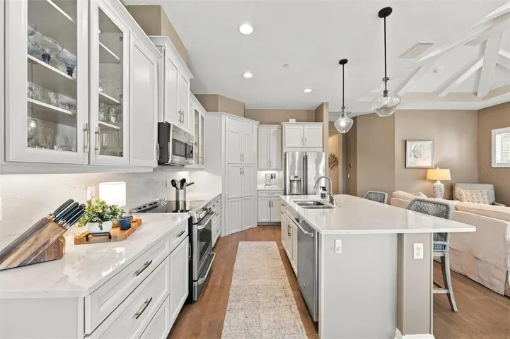 The well-designed kitchen shines with GE Café stainless steel appliances, elegant quartz countertops, and a spacious walk-in pantry.