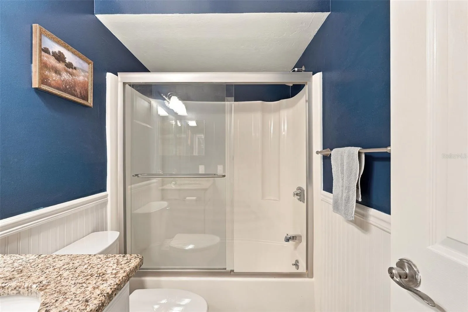 Guest Bathroom Features Granite Countertops and Tub/Shower Combo