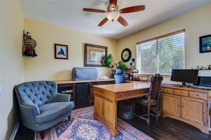 Back bedroom (set up as home office) with double window and sliders to pool area