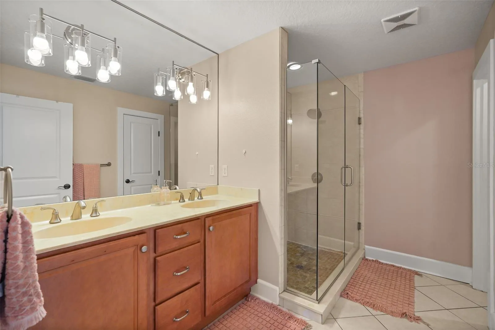 Primary bathroom with dual vanity and glass-enclosed shower