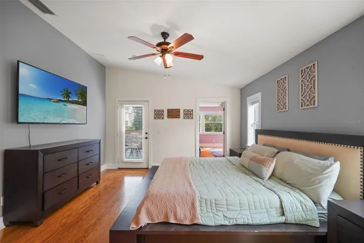 Primary bedroom with ceiling fan and deck access