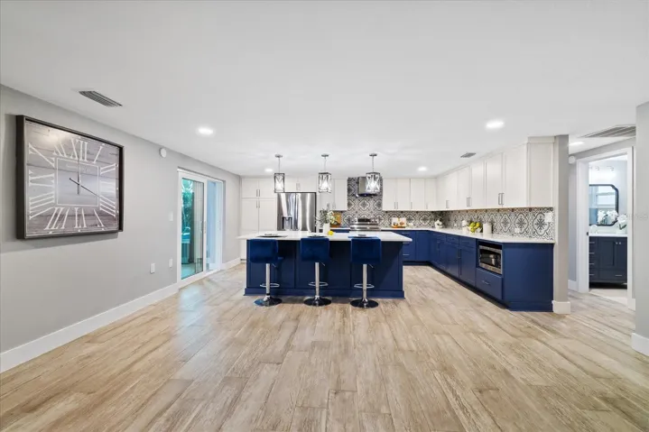 kitchen showing door to guest bedrooms and full bath and sliders to family room