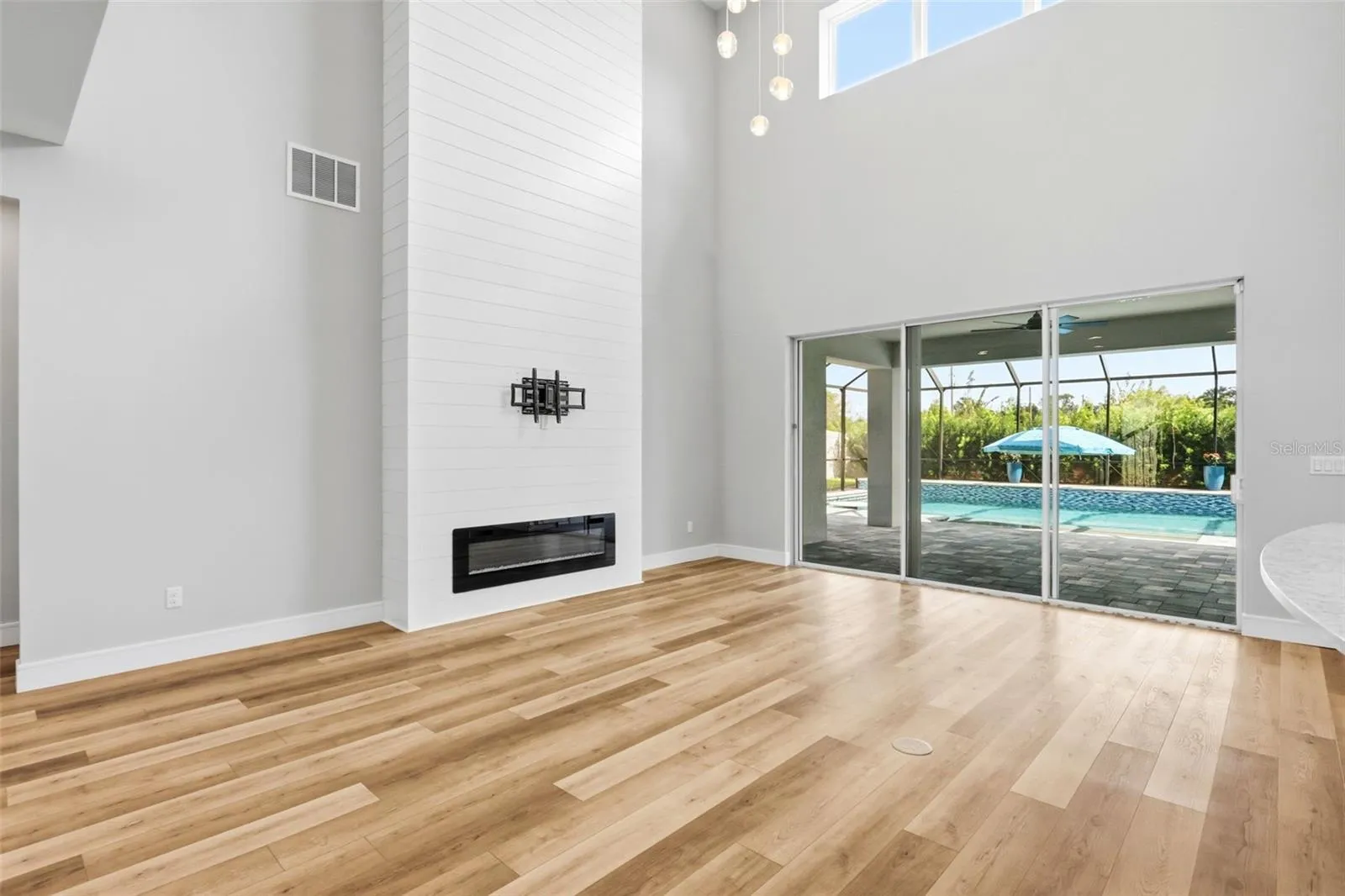 Soaring ceilings the the living area with sliding doors out to the covered lanai and enclosed pool.