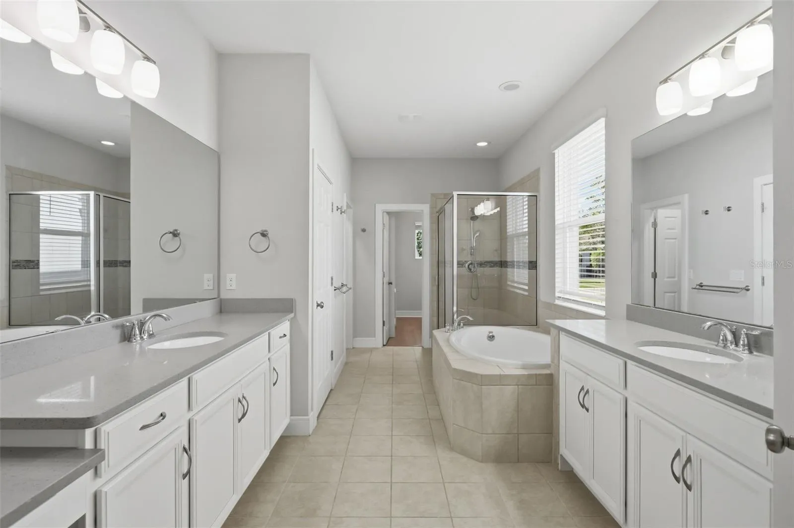Primary bathroom features two vanities, 2 walk-in closets, garden tub and large shower
