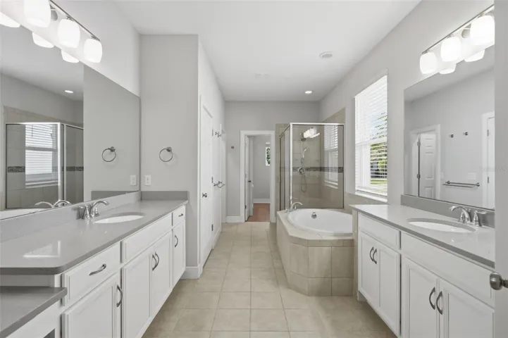 Primary bathroom features two vanities, 2 walk-in closets, garden tub and large shower