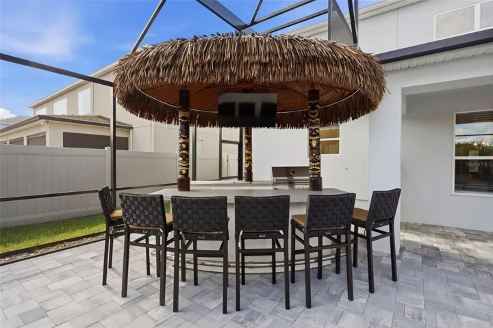 Tiki bar and outdoor kitchen with huge paved patio provides such an amazing entertaining area