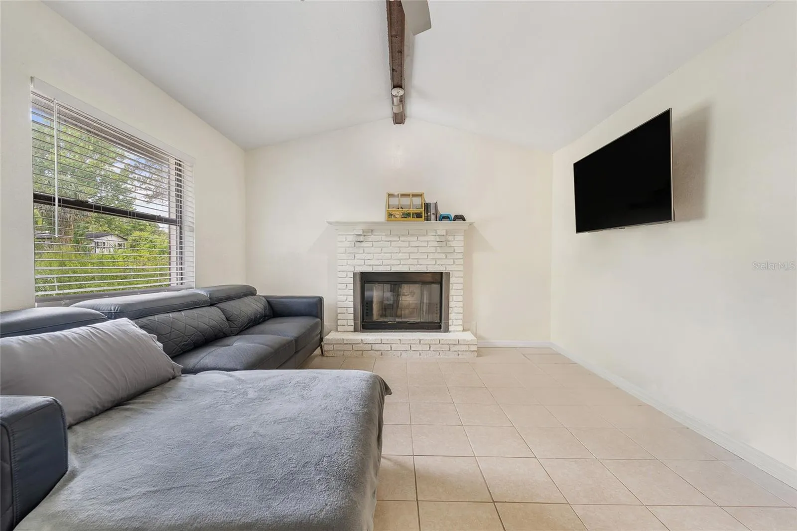 View of fire place with large window offering natural light.