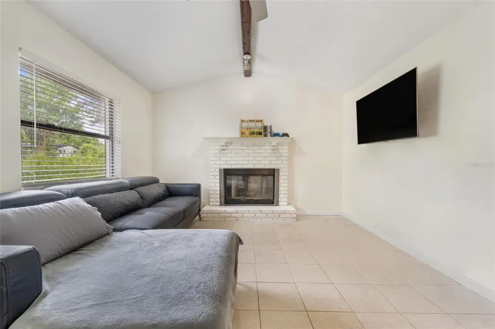 View of fire place with large window offering natural light.