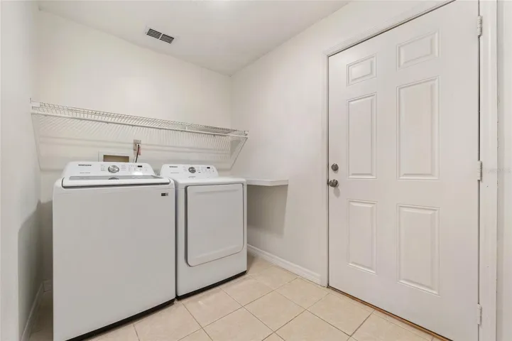 Laundry room with included washer and dryer leads out to 2 car garage.