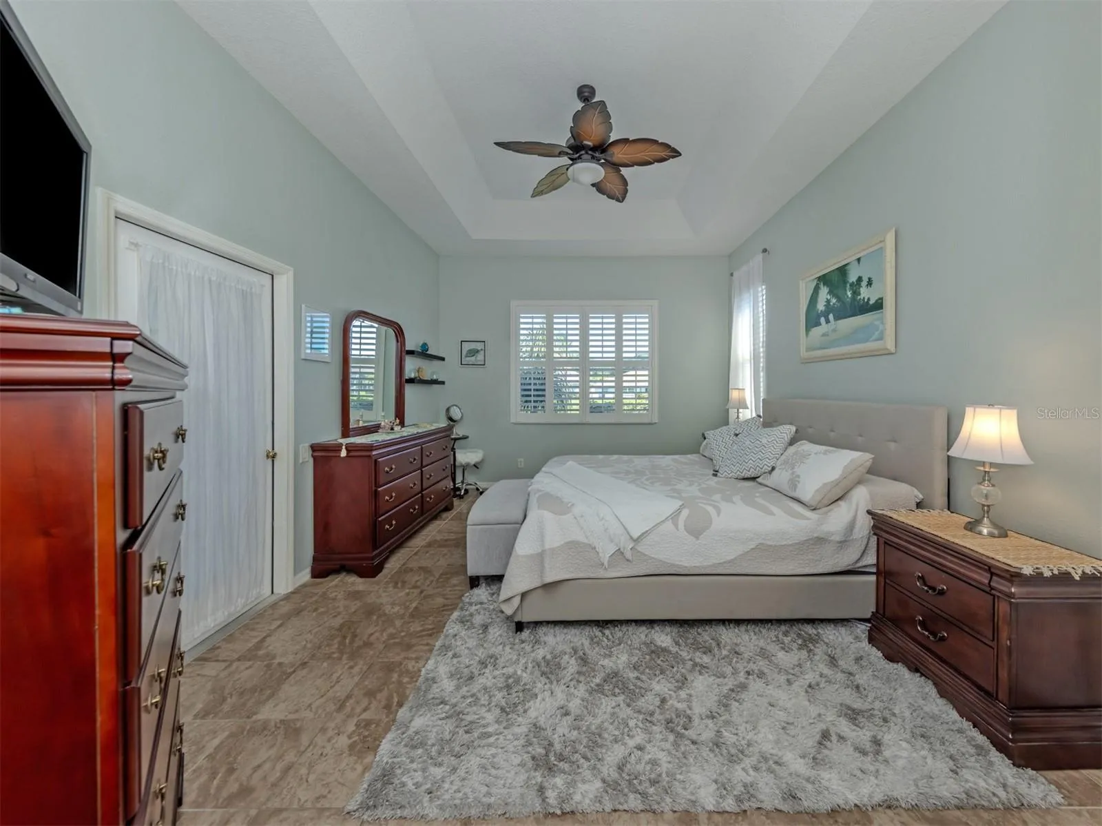 Your own private slice of paradise! This beautiful primary suite is a delightful retreat, featuring an elegant tray ceiling, ceiling fan, gorgeous ceramic tile flooring that flows seamlessly throughout the home, and lovely lake views! Step directly onto the extended lanai to enjoy the Florida sunshine, while two closets, including a generous walk-in, provide plenty of room for your wardrobe!