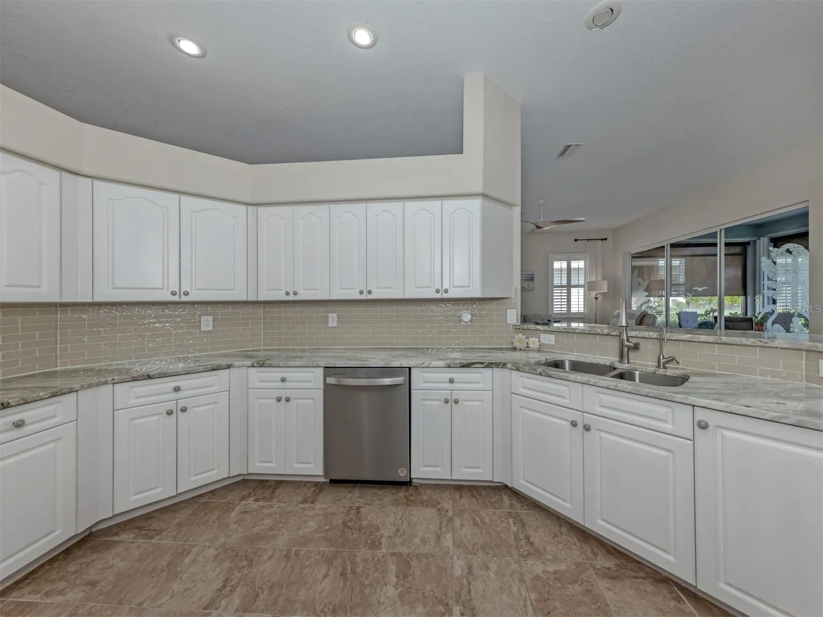 Crisp white cabinetry brings a fresh, timeless elegance to the kitchen, offering plenty of storage while beautifully complementing the rich granite countertops!