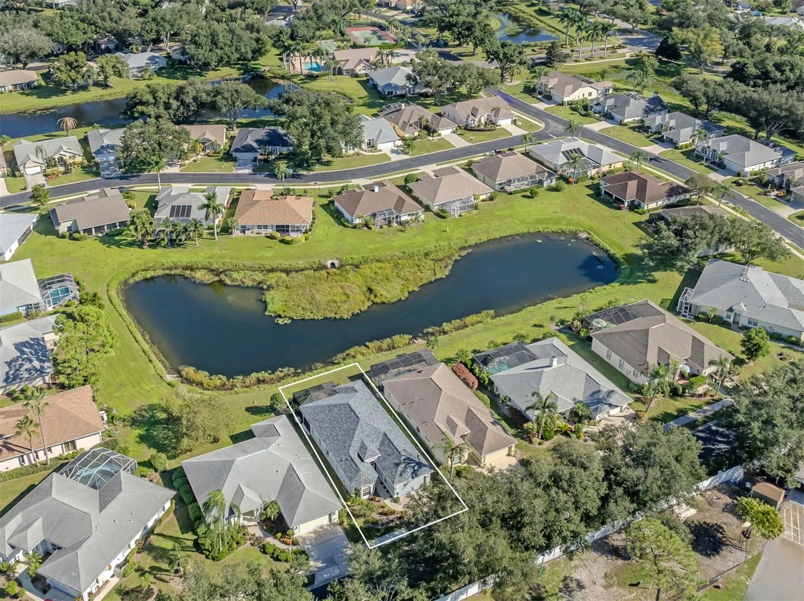 A bird’s-eye view of this lovely neighborhood, showcasing the home's beautiful setting, sparkling lake, and picturesque surroundings in the Isles of Chestnut Creek!