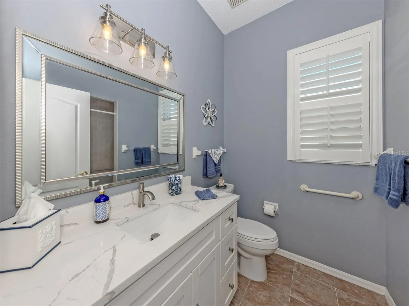 A little luxury for everyone! This beautifully updated guest bathroom shines with a gorgeous quartz countertop, stylish new lighting, a lovely new mirror, and a refreshing walk-in shower. A delightful blend of elegance and comfort, perfectly situated to serve both guest bedrooms and visiting friends and family!