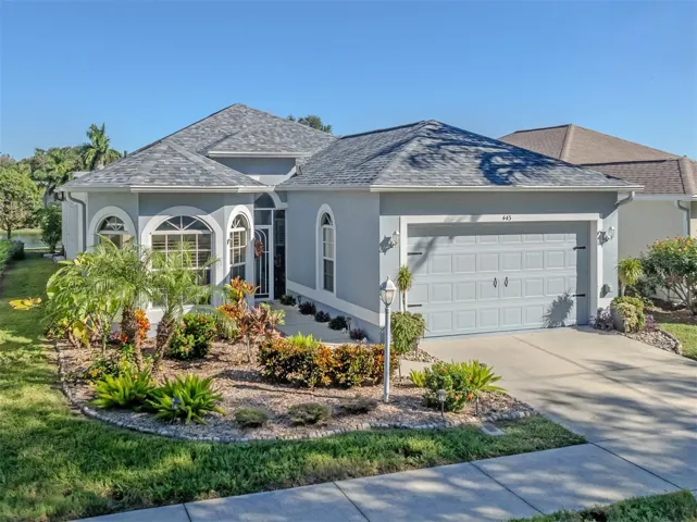 Beautiful curb appeal welcomes you home, featuring a charming bay window, lush mature landscaping, and a lovely glimpse of the peaceful lake beyond!