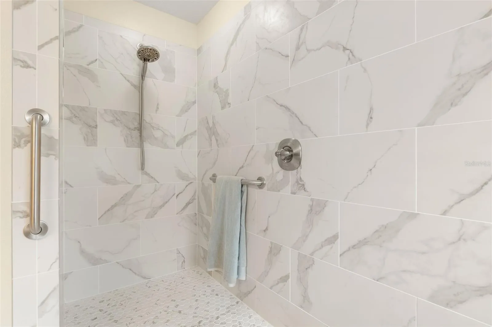 A little luxury goes a long way! The primary shower's generous walk-in design and convenient grab bar combine beautiful style with everyday practicality.