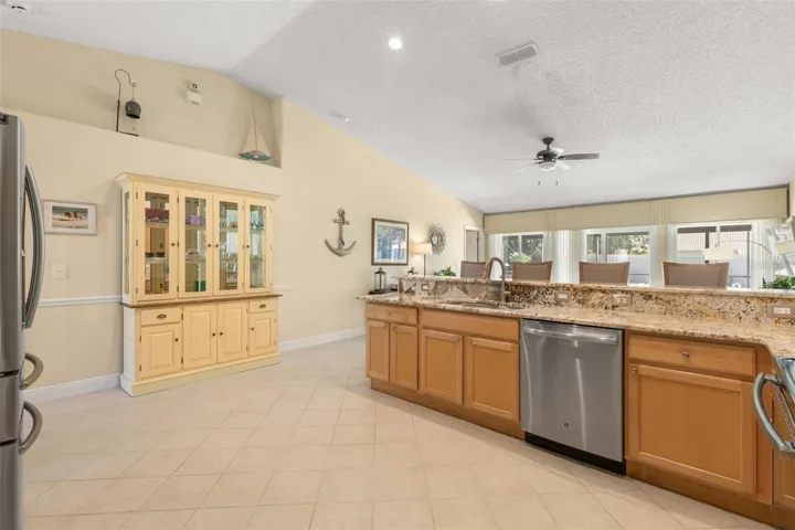 This view showcases the kitchen’s spacious, open layout, offering plenty of room to move around, while the elevated display shelf above the wall provides a distinctive spot for decorative accents and personal treasures.
