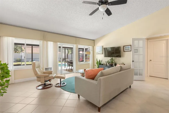 A cozy retreat for movie nights or quiet afternoons, this sunlit living room offers comfortable surroundings, generous windows, and sliding glass doors that lead directly to your poolside escape.
