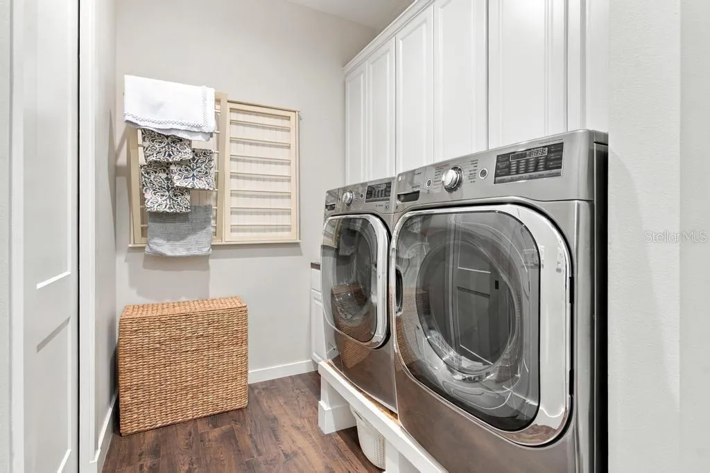 Inside laundry room #1 with built in iron board, sink, and access to walk-in closet