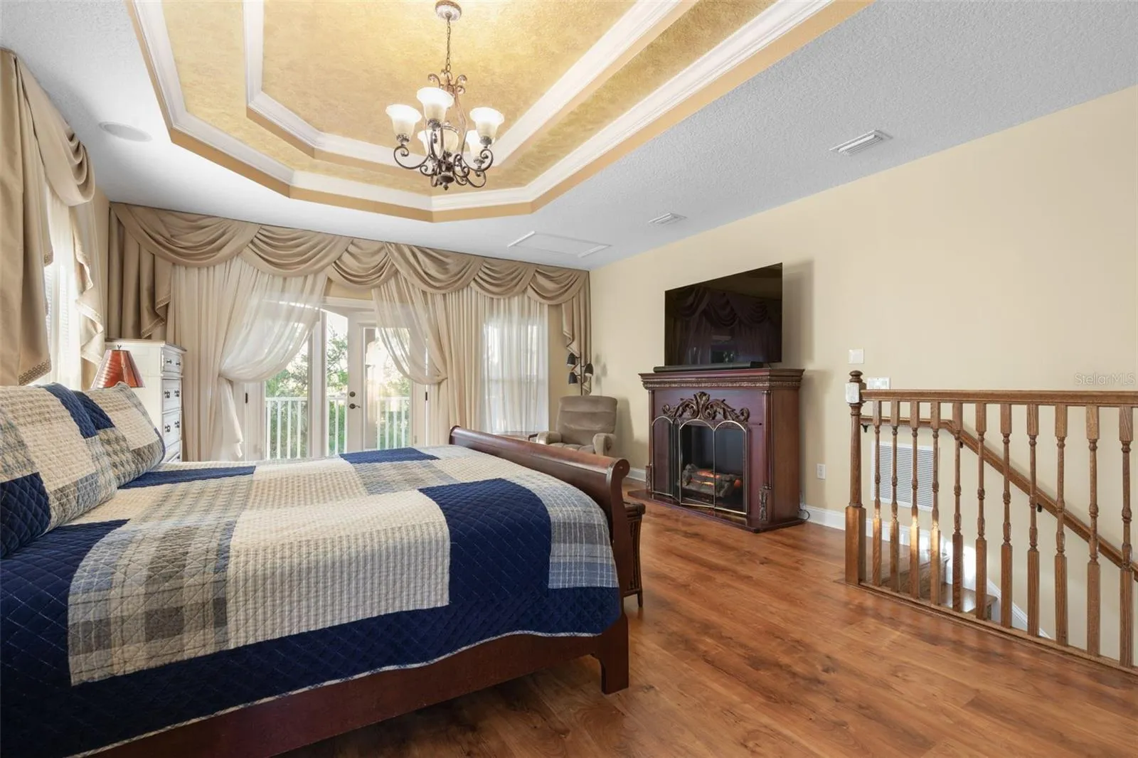 French doors open to a private balcony overlooking the wooded surroundings, offering a peaceful escape just steps from the bedroom.
