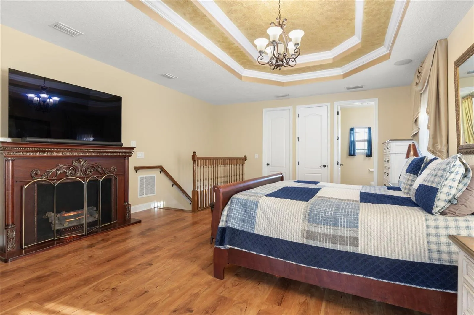 Warm wood-look flooring, an elegant tray ceiling and generous living space create a comfortable setting for a private upstairs retreat.