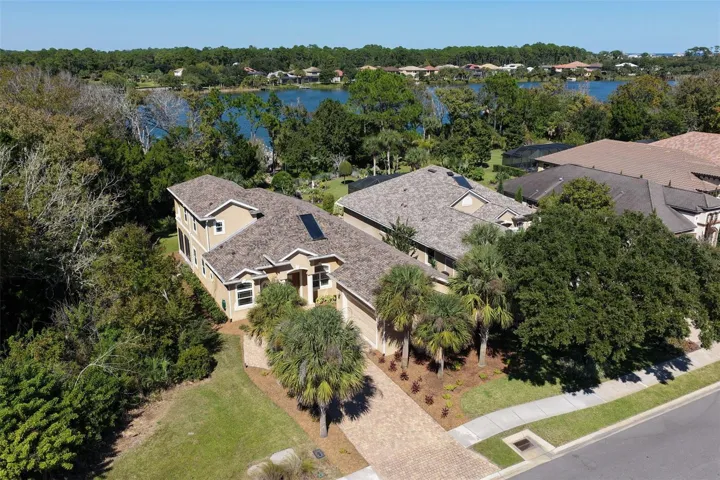 Distinctive architectural design, lush landscaping, and a paver driveway, with Emerald Lake providing a beautiful backdrop to this Palm Coast Plantation home.