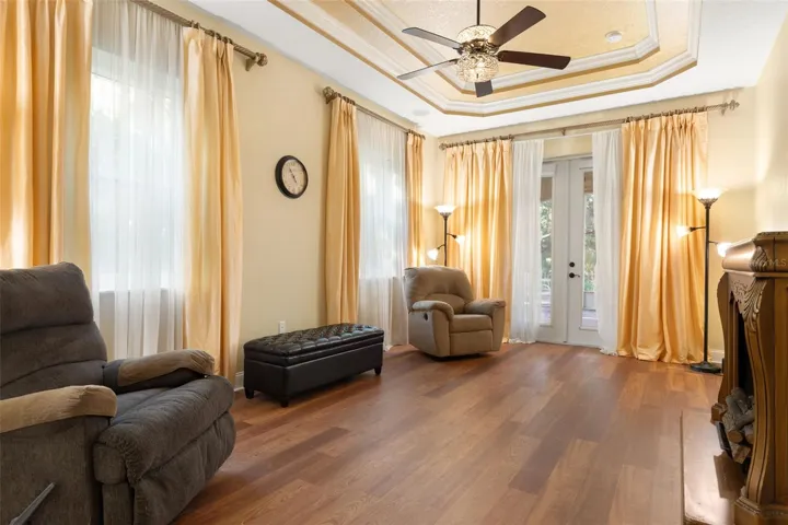 A spacious first-floor primary retreat featuring an elegant tray ceiling, abundant natural light and French doors opening to the screened lanai.