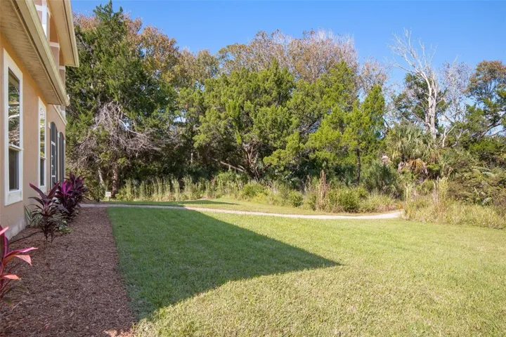 Peaceful backyard surrounded by natural greenery with a walkway leading toward Emerald Lake.