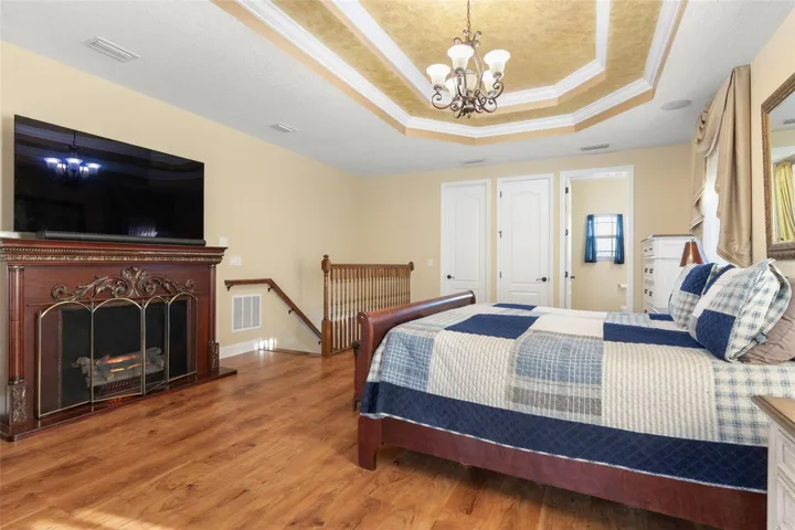Warm wood-look flooring, an elegant tray ceiling and generous living space create a comfortable setting for a private upstairs retreat.