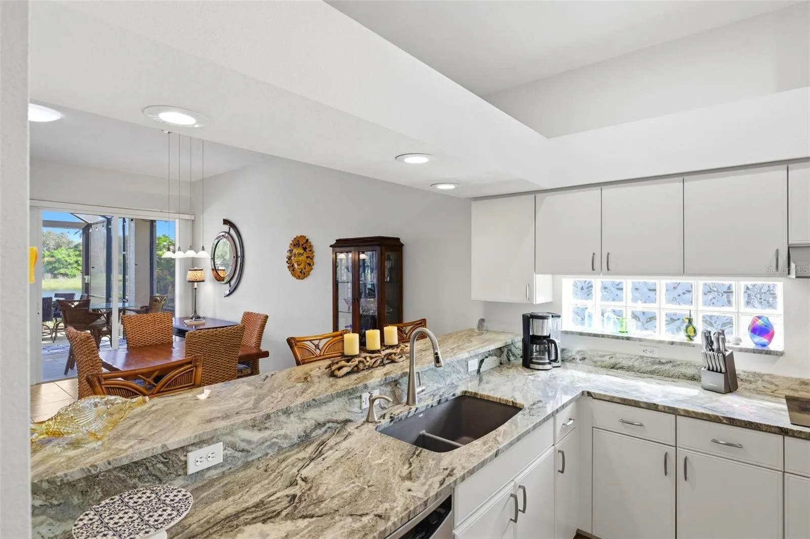 Kitchen and breakfast bar open to dining and living areas