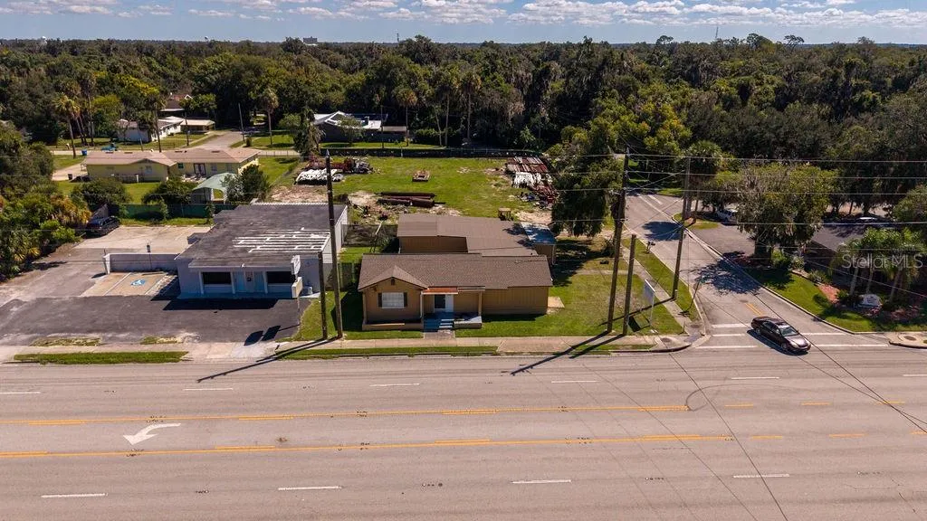 Aerial of front of building facing major thoroughfare 15-A. Building and vacant lot zoned B4.
