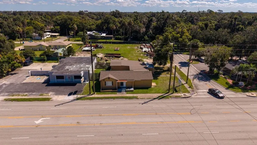Aerial of front of building facing major thoroughfare 15-A. Building and vacant lot zoned B4.